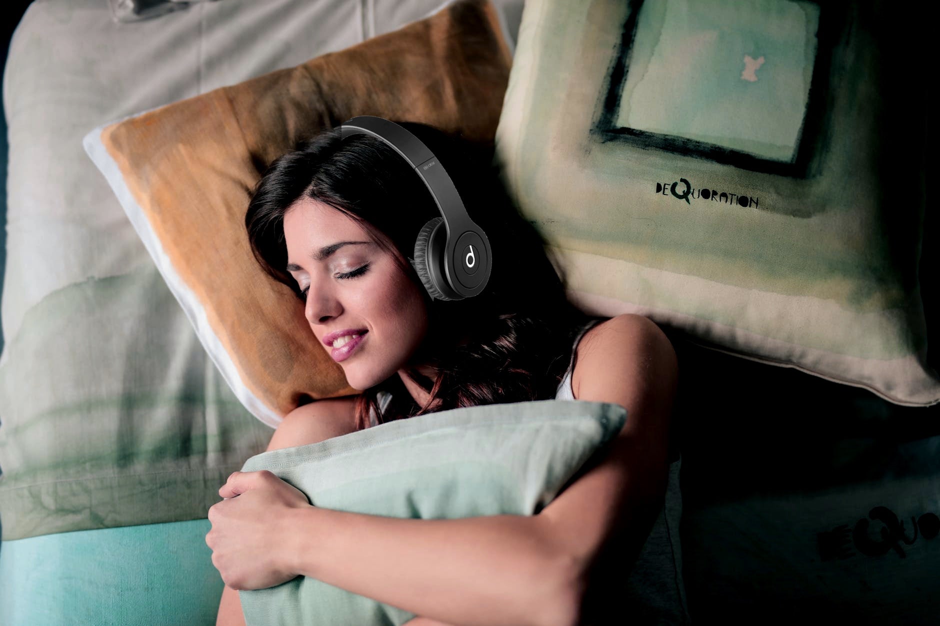 woman listening to binaural beats with headphones while asleep