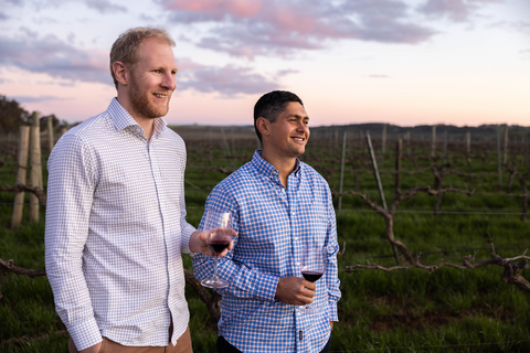 Jack Walker and Luke Broadbent holding glasses of red wine