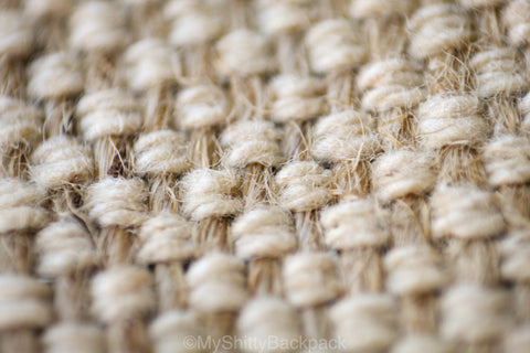 This photo shows a close-up of the hemp/cotton material. The vertical strands are the darker hemp strands, and the horizontal strands are the lighter colored cotton strands