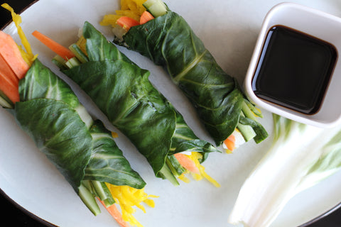 A plate with three veggie spring rolls, made out of chard leaves