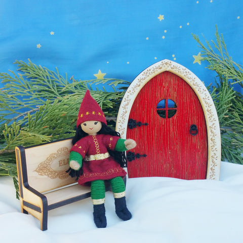Kindness elf sitting on wooden Elf bench