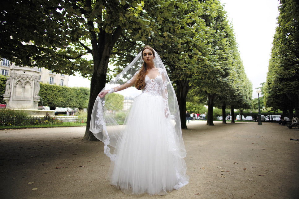 Claudia: Long sleeved Couture Bridal gown of French lace applique on nude mesh and a sleek heavy 6ply silk crepe skirt. Shown with a full detachable tulle overskirt. Handmade in our Atelier on Russian Hill in San Francisco.