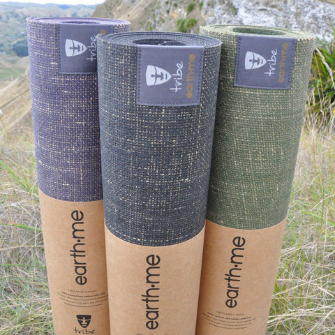 Three Earth.Me yoga mats (Amethyst, Cosmos & Olive colours) standing vertically side by side in a paddock - TRIBE | Eco Yoga Store