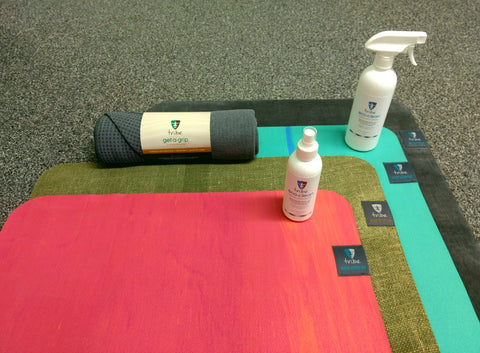 TRIBE Wanderer Travel Mats, Earth Me & Wanderer Yoga Mats on top of each other with TRIBE Eco Clean Mat Cleaner bottles & a TRIBE Get a Grip Yoga Towel | Eco Yoga Store