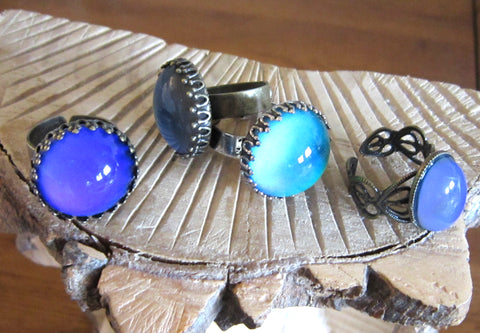 circular mood rings lying on some wood turning blue and purple mood colors