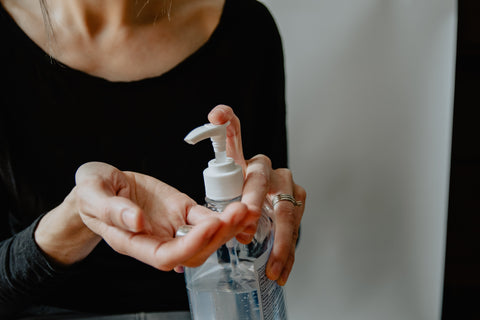 Woman pumping sanitizer gel out of the bottle and into hands