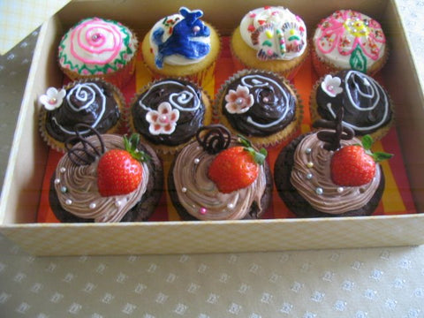 assorted chocolate cupcakes with flowers, strawberries and fondant decorations