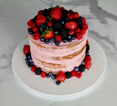 Naked berry cake decorated with strawberries, raspberries, blueberries and blackberries