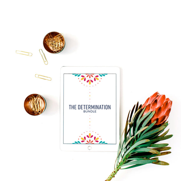 The Determination Bundle planner being used digitally on an iPad, resting on a home office desk with paper clips and flowers