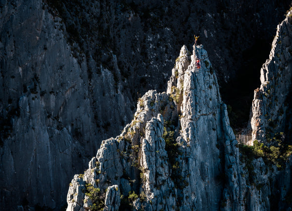 Two rock climbers stand atop a limestone fin in El Portero Chico Park, Mexico, in the morning sun.
