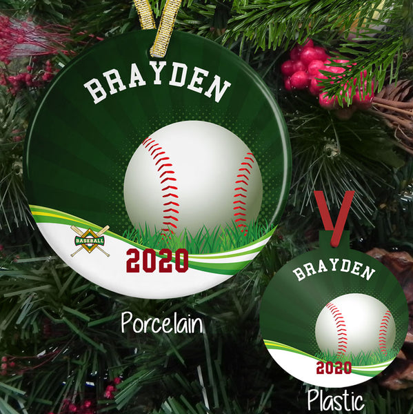 Christmas Ornament in plastic and porcelain -green sunburst backdrop with baseball sitting in grass on a swirl bottom cross bags and baseball diamond small on left bottom. Personalized with any arched text on top and straight text on bottom.