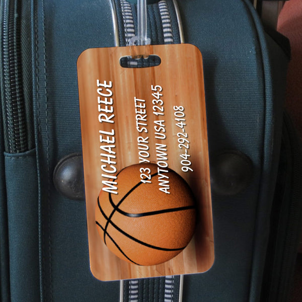 Basketball sitting on wood floor custom sports bag tag personalized with name and contact info