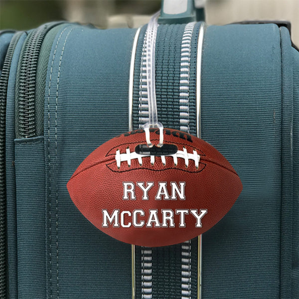 Football Shaped Bag Tag shown on luggage