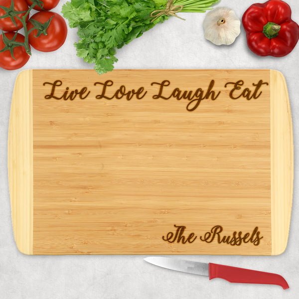 Two Tone bamboo wood cutting board with Live Love Laugh Eat across the top and your name or custom text on the bottom right
