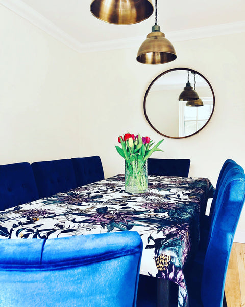 Velvet blue dining chairs in a dining room with brass lights
