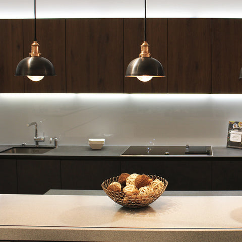 Dark kitchen interior with pewter pendants hanging over worktop 