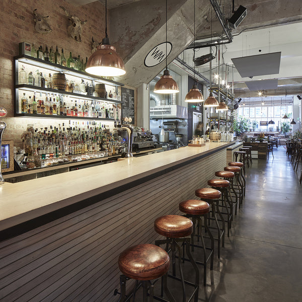 Bar interior with industrial stools and handcrafted pendants