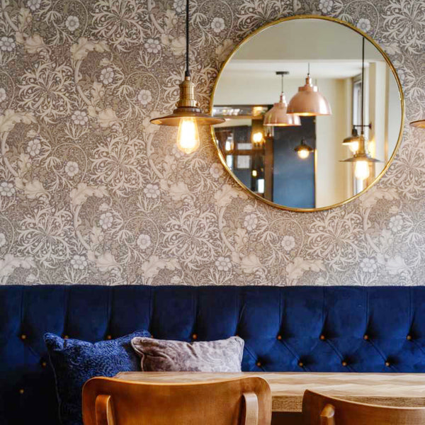 Blue velvet upholstery in a pub interior with brass lights