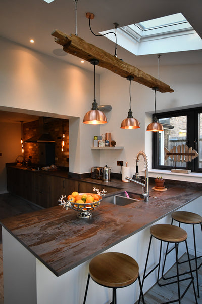 Copper toned industrial lights in a renovated kitchen