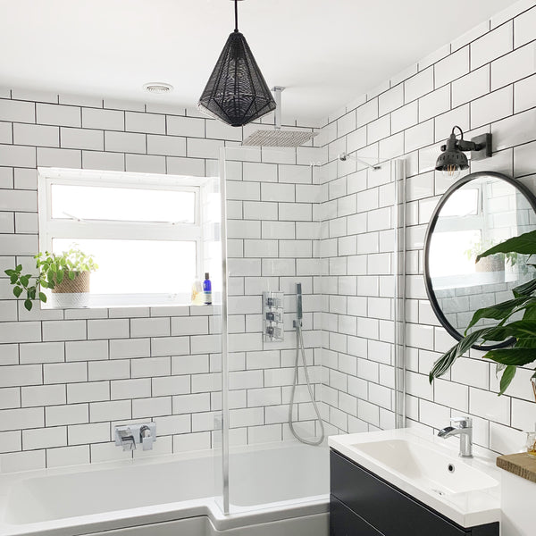 Handcrafted wire cage industrial light in a white bathroom interior