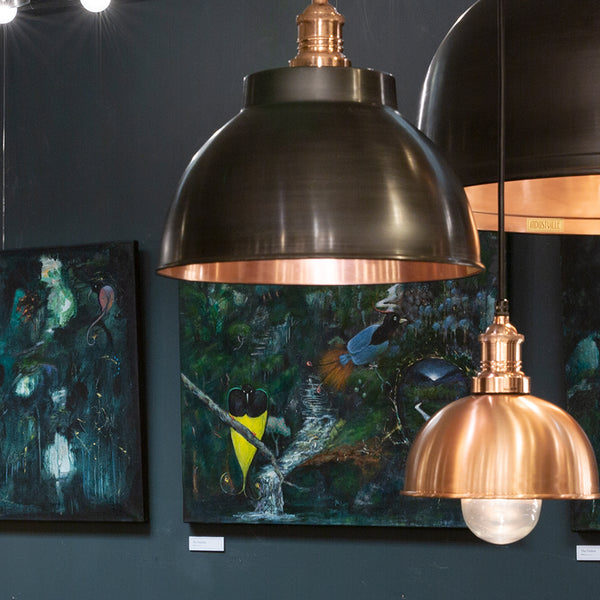 Trio of industrial lights in Industville showroom with unique art