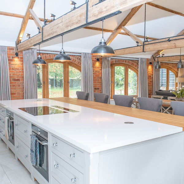 Industrial-styled kitchen interior with exposed wooden beams and industrial lights