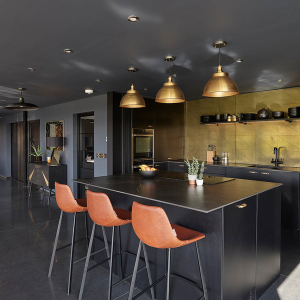 Black open plan kitchen with brass lights