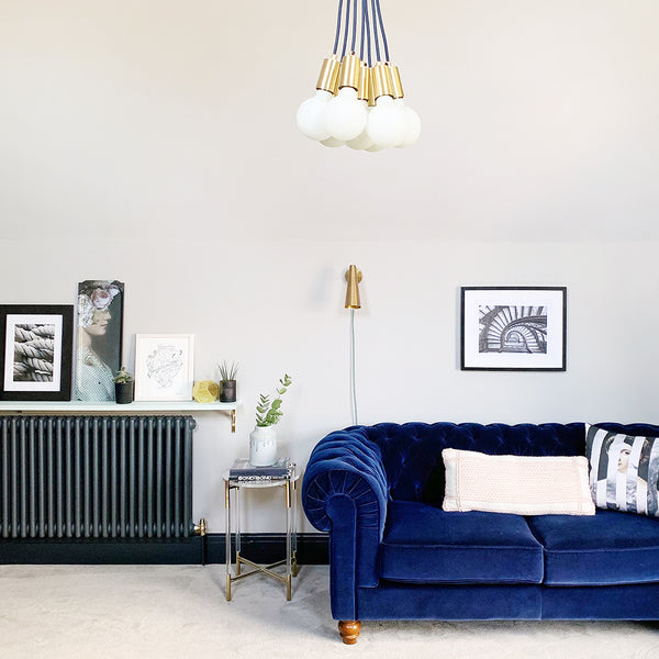 Mid-century modern living room interior with vintage pendant and blue velvet sofa