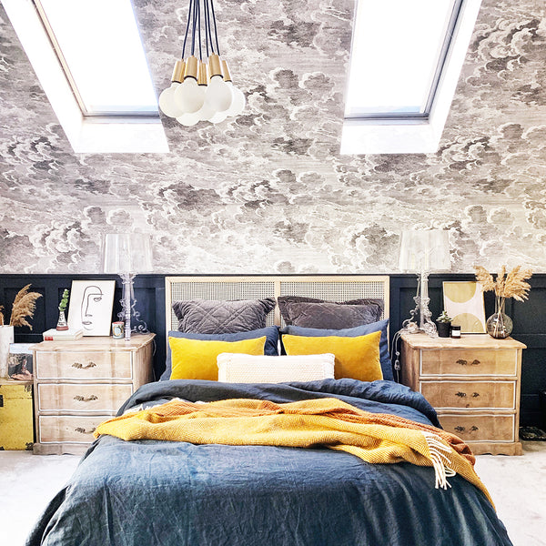 Vintage-inspired bedroom interior with patterned wallpaper and industrial pendant