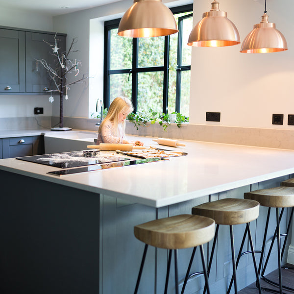 Girl cooking in a kitchen with copper industrial lights