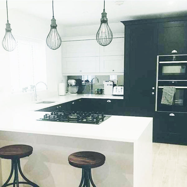 Monochrome kitchen interior with a trio of handcrafted cage lights 