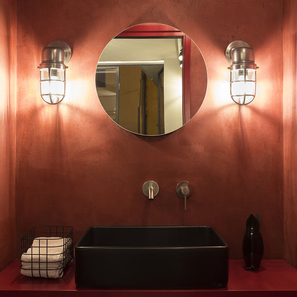 Ruby red bathroom interior with a statement mirror and vintage wall lights 