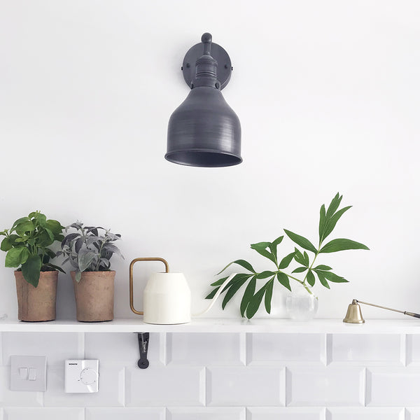 Industrial pewter wall light in a white kitchen interior