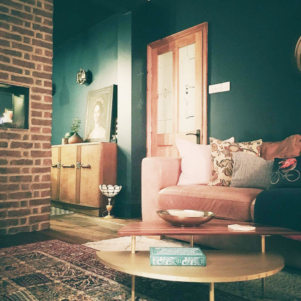 Dark living room interior with pink sofa and bulkhead lights