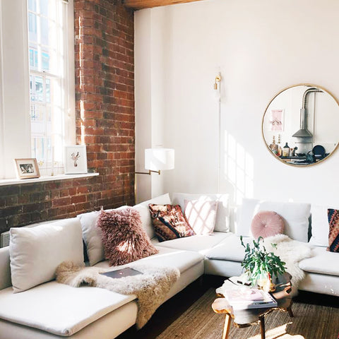 Industrial inspired living room decor with exposed brick wall and brass wall light