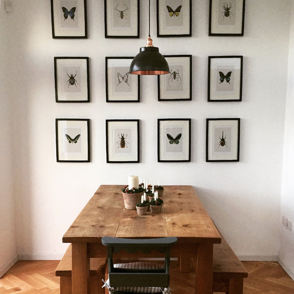 Gallery wall art with a wooden table and industrial pendant