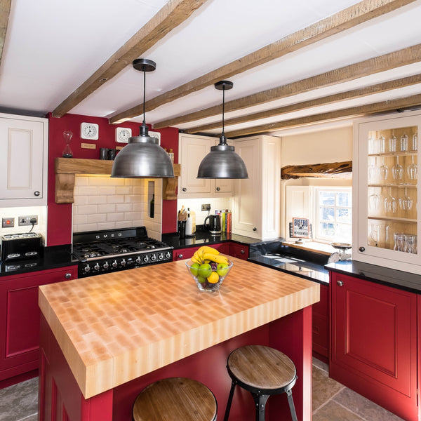 Red traditional style kitchen with duo of pendants above kitchen island