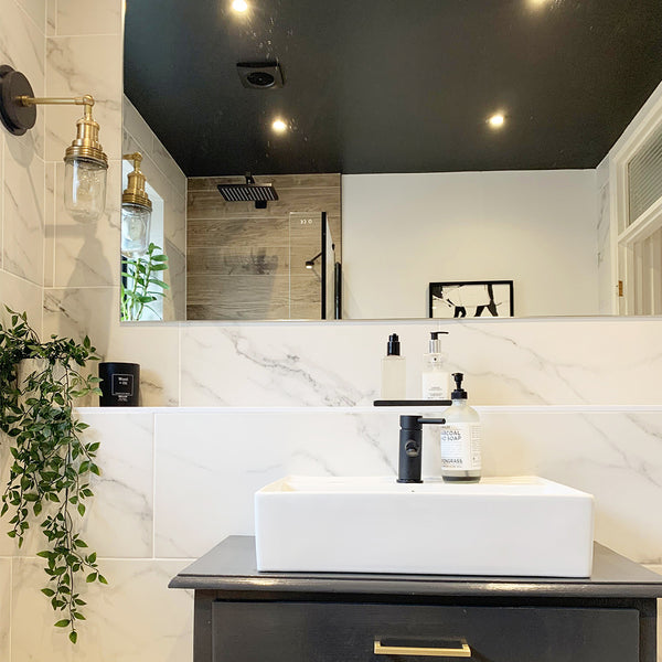 Marble bathroom interior with greenery and waterproof wall light