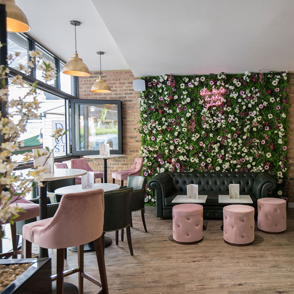 Bocca Social interior with floral wall, neon sign and brass pendant lights