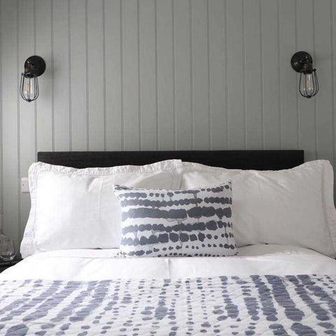 Grey bedroom interior with textured bedding and orlando wall lights