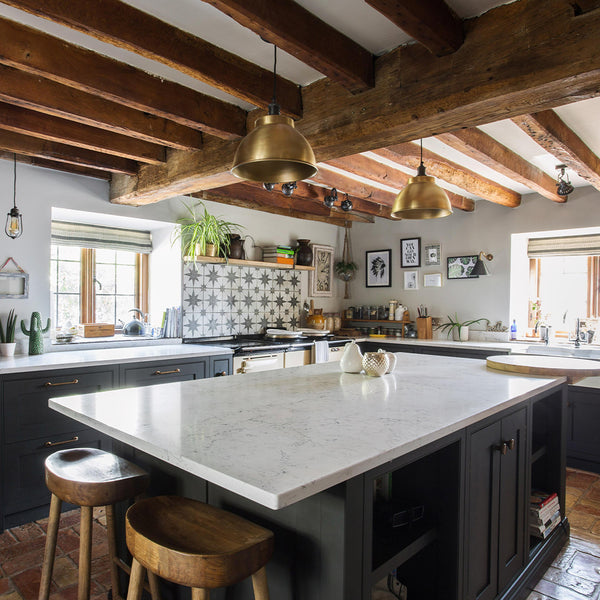 Industrial inspired kitchen interior with exposed wooden beams and industrial lighting