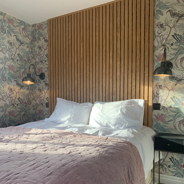 Bedroom interior with statement wallpaper and retro wall lights