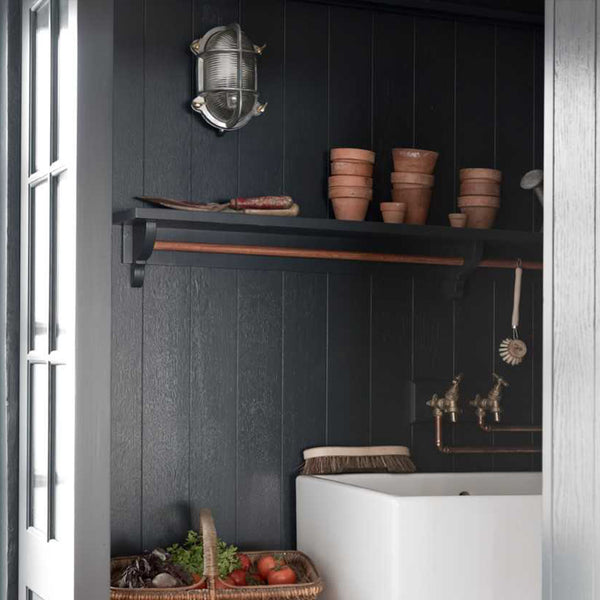 A dark interior design with wooden shelves and pottery