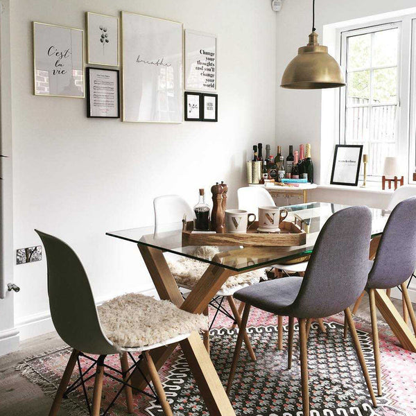 A dining room with textured seating, rug and metallic lights