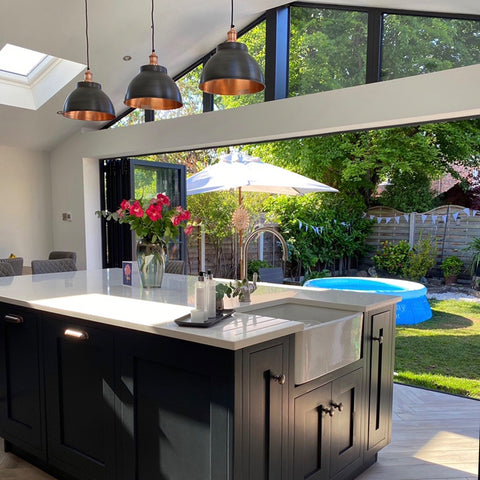 A modern kitchen opening into a summery garden