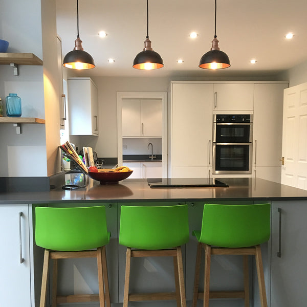 A colourful kitchen interior with three pendant industrial lights