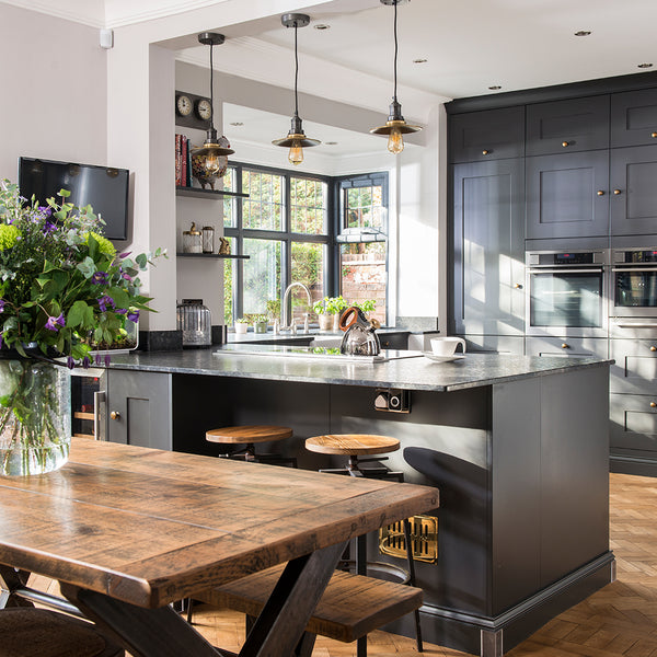 A smart kitchen interior with wooden furniture and grey cupboards