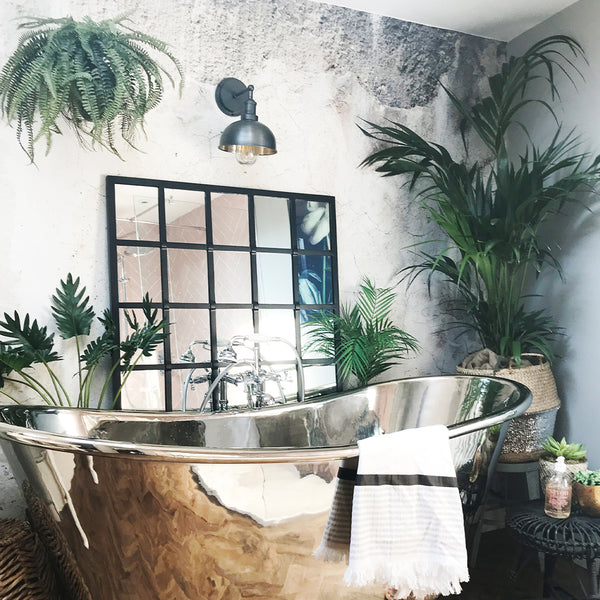 Bathroom interior with chrome bath and black mirror 