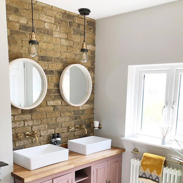 Pink bathroom interior with duo of mirrors and pendants