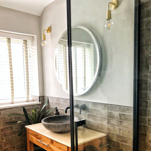 Bathroom with large circular mirror and large window